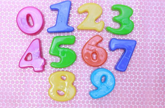 Numbers 0 to 9 on pink and silver foil background