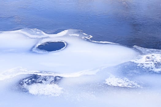 Fragment of frozen river in early winter