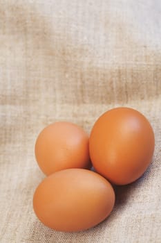 Fresh brown eggs on a beige fabric background