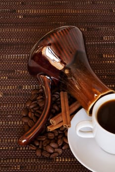 Coffee beans and drink in a white cup on a dark background