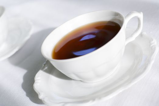 Tea in porcelain teacup. Focus on the cup handle (shallow depth of field), aRGB.