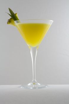 pineapple, rum, lemon cocktail in cocktail glass, moody background
