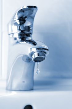 Water dripping from a water faucet, closeup