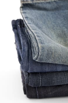 folded new blue jeans on a white background