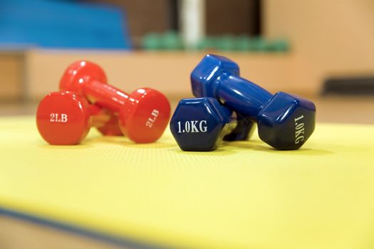 Red and blue dumbbells in a modern hall for sports trainings