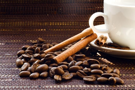 White cup and coffee beans on a dark wattled background