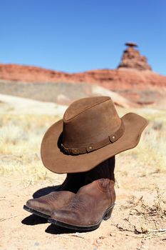 boots and hat in front of mexican hat rock
