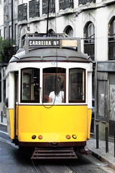 Typical yellow Tram in old Lisbon street