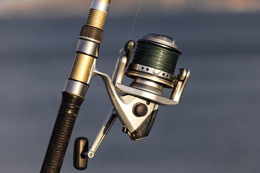 fishing reel on the beach with summer sunlight