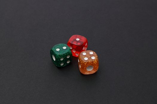 3 coloured dices on dark background