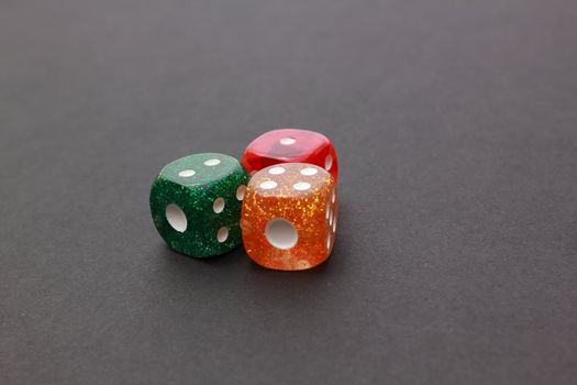 3 coloured dices on dark background