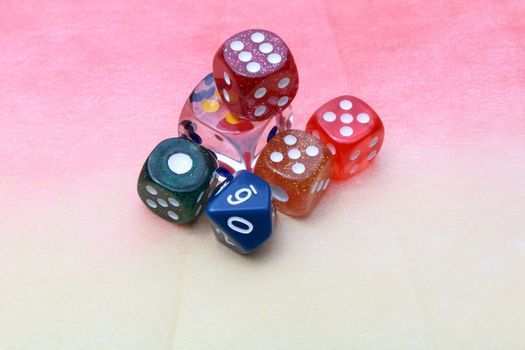 6 coloured dices on pinkish background