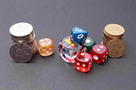 6 coloured dices with coins on dark background