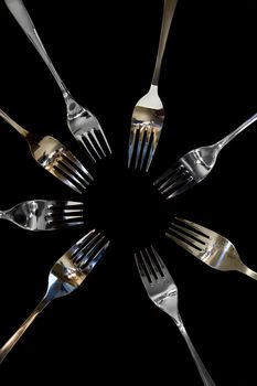 forks surrounding a heart shape petal with rose petals for a concept on romantic dining on white background