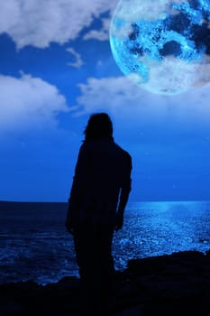 a lone woman looking sadly over the cliffs edge under the full moon as if the weight of the world is on her shoulders