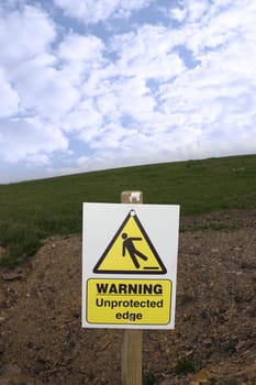 a warning sign about an unprotected edge on a construction site with clipping path