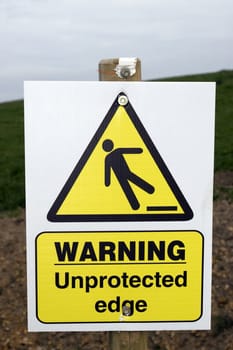 a warning sign about an unprotected edge on a construction site with clipping path