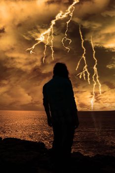 a lone woman looking sadly over the cliffs edge in county clare ireland during a thunder storm