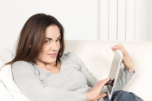 woman with tablet on sofa at home