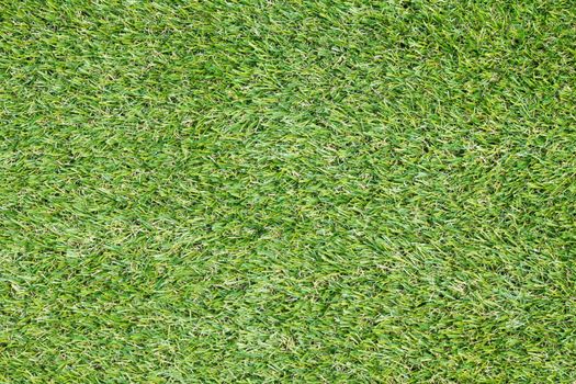 Background texture with fake grass in a public children playground, top view