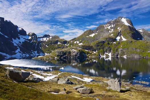 Picturesque mountain lake surrounded by sharp peaks on Lofoten islands in Norway
