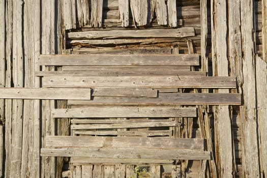 Old wooden facade texture with covered window on abandoned house