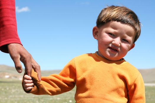 MONGOLIA, AUGUST 06, 2008 - mongolian boy keeping fathers by arm