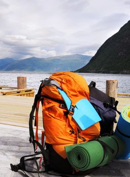 Tourists backpack on a pier in Norwagian fjords 