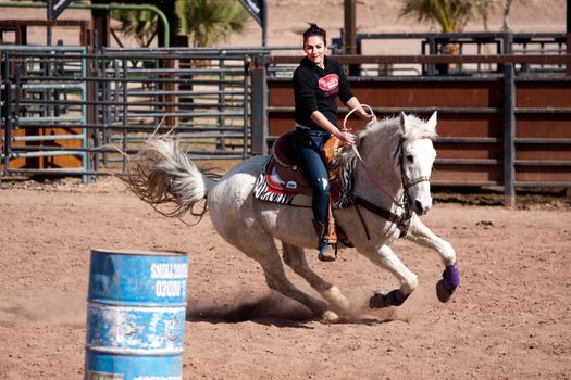 Women horse barrel race in corral in las vegas