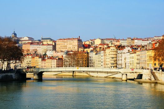 First morning light on the Saone river with typical bridge and old architecture, european style historical buildings and church.