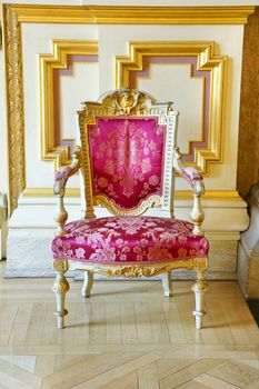 Beautiful rich and luxurious old vintage antique pink silk chair with gold frame showing the wears and tears of years of service.