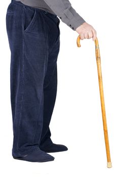 Profile of bottom half of an old man or elderly person walking with a wood cane, wearing blue corduroy and slippers, isolated on white.