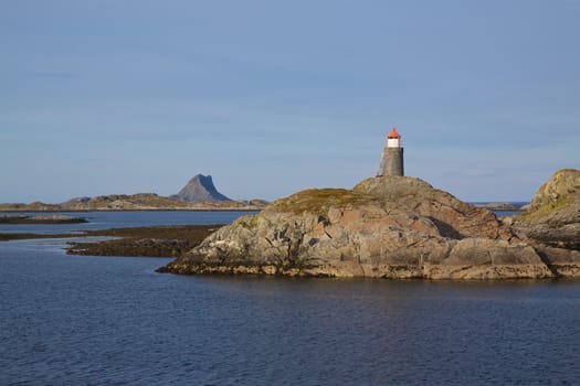 Small lighthouse on rocky islands on norwegian coast near Lofoten islands