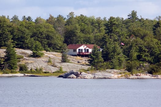 Lone cottege on stone lake shore