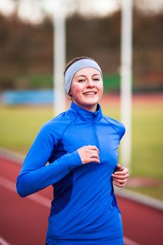 Young woman running at a track and field stadium