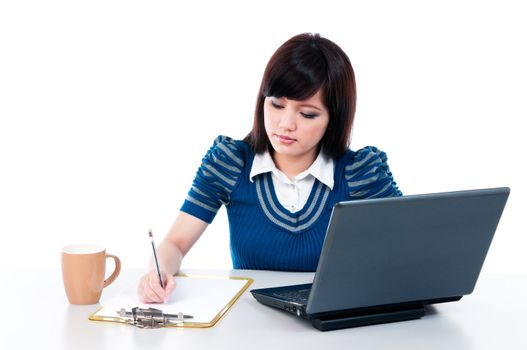 Portrait of a cute young female with laptop and writing on clipboard, isolated on white background.