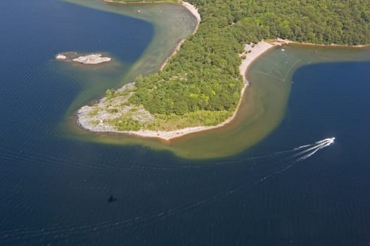 Small boat tracks on surface of water in sunlit