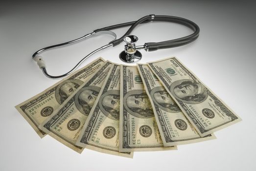 Money and stethoscope to illustrate the cost of health care