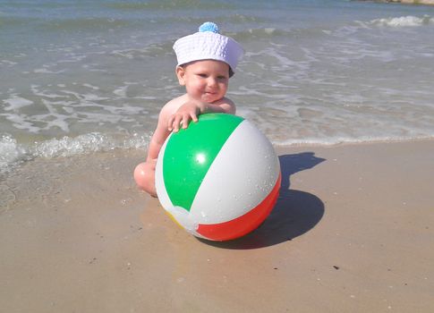 The kid with the ball on the beach
