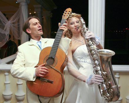 The bride and groom are entertained guests at a party in honor of their wedding 
