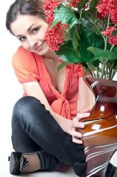 Portrait of a young beautiful girl with a bouquet of red flowers in vase