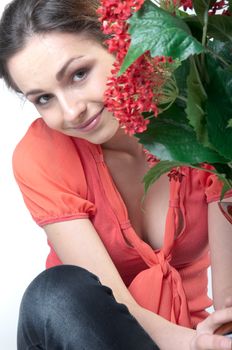 Portrait of a young beautiful girl with a bouquet of red flowers in vase