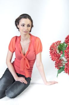 Portrait of a young beautiful girl with a bouquet of red flowers in vase