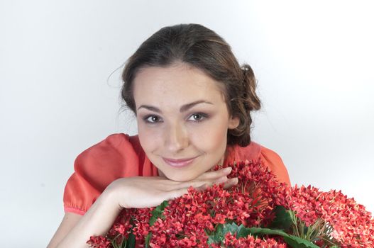Portrait of a young beautiful girl with a bouquet of red flowers in vase