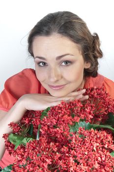 Portrait of a young beautiful girl with a bouquet of red flowers in vase