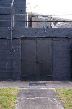 A double doorway entrance into a historic fort near Charleston, South Carolina. Includes a large metal door on a black background.