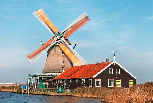 Image of a dutch windmill from Zaanse Schans, during a windy day with motion blur on the sails. 