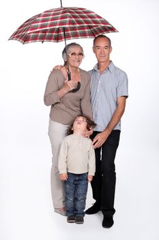Grandparents and child with an umbrella