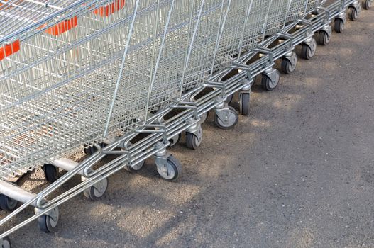 Row of metal shopping carts at supermarket parking