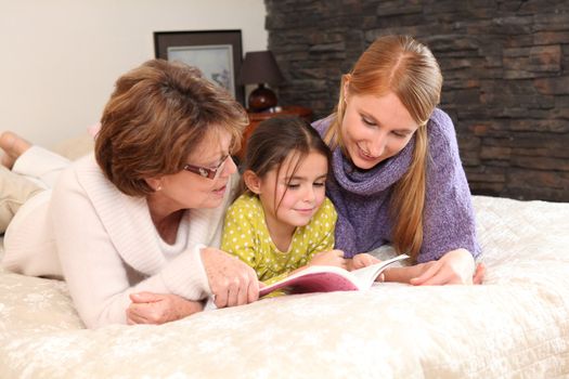 Mother and grandma reading with little girl